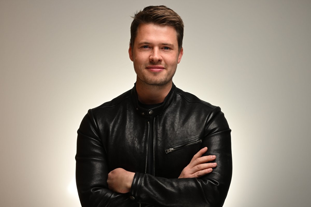 James Sackl, Melbourne founder of Wallace Biotechnologies and Terraform Technologies, in a black leather jacket, arms crossed, against a soft cream backdrop.
